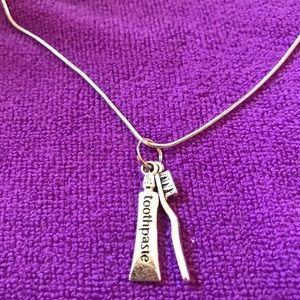 Whimsical toothbrush and toothpaste necklace.